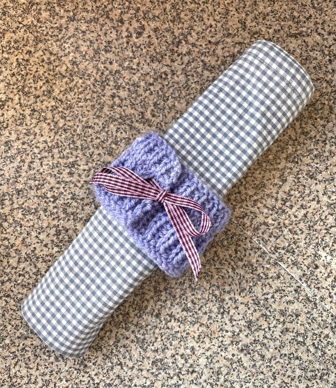Napkin with knitted napkin ring and bow.
